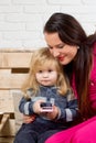 Woman and child play on cell phone. Royalty Free Stock Photo