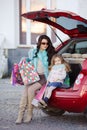 A woman with a child after shopping load the car Royalty Free Stock Photo