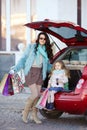 A woman with a child after shopping load the car Royalty Free Stock Photo