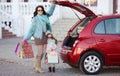 A woman with a child after shopping load the car Royalty Free Stock Photo