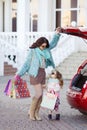 A woman with a child after shopping load the car Royalty Free Stock Photo