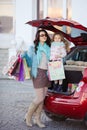 A woman with a child after shopping load the car Royalty Free Stock Photo