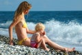 Woman and child sit on seaside Royalty Free Stock Photo