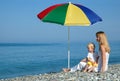 Woman and child sits under an umbrella Royalty Free Stock Photo