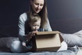 Woman and child sitting on home bed and unwrapping delivered package. Online order of high quality goods at affordable prices: