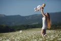 Beautiful mother and her daughter playing in spring flower field Royalty Free Stock Photo