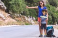 A woman with a child stop the car on the road, a hitchhiker with children