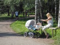 A woman with a child in the stroller resting in the Park. Russia. Saint-Petersburg. Summer 2017.