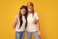 Woman with child teen girl. Mommy and daughter isolated on yellow background studio portrait. Parenthood childhood