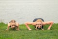 Woman and child are training near the lake on the green grass Royalty Free Stock Photo