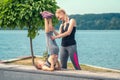 Woman and child are training near the lake at the summer park Royalty Free Stock Photo