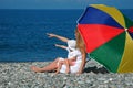 Woman with child under umbrella on beach Royalty Free Stock Photo