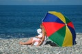 Woman with child under umbrella on coast Royalty Free Stock Photo