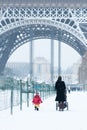 Woman and child walking by the Eiffel Tower