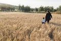 A woman and a child walking through a wheal field