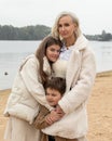 Woman child walks beach cold weather, mom with son and daughter in light clothes. Have fun together. Concept of tenderness, love, Royalty Free Stock Photo