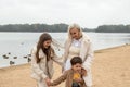 Woman child walks beach cold weather, mom with son and daughter in light clothes. Have fun together. Happy family concept