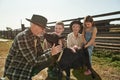 Woman and children look at man caress goat on farm Royalty Free Stock Photo