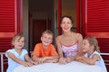 Woman with children sits in number on verandah Royalty Free Stock Photo