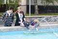 A woman with children walking around the city and stopped to rest at the fountain