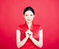 Woman in chinese cheongsam with congratulation gesture