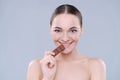 Woman, chocolate and bite in studio portrait with smile, eating and skin glow for beauty by