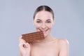 Woman, chocolate and bite in studio portrait with smile, eating and skin glow for beauty by