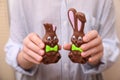 Woman With Chocolate Easter Bunnies On Beige Background, Closeup