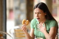 Woman choking eating doughnut in a bar Royalty Free Stock Photo