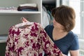 Woman chooses a blouse in wardrobe in apartment