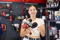 Woman chooses and buys paint spray gun in hardware store Royalty Free Stock Photo