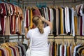 Woman chooses clothes going through the broadcaster in the store at the market Royalty Free Stock Photo