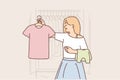 Woman chooses clothes from wardrobe going to party or sorting out t-shirts for thrift store Royalty Free Stock Photo