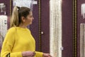 A woman chooses crystal lamps in a store. Young blonde in a yellow sweater. modern interior design