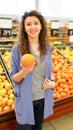 Woman chooses fruits and vegetables at farmers market and holding orange. Zero waste. Sustainable lifestyle