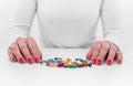 Woman chooses medicine from a handful of different color tablets. Royalty Free Stock Photo