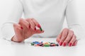 Woman chooses medicine from a handful of different color tablets. Royalty Free Stock Photo