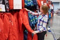 Woman chooses ski jumpsuit in sport store Royalty Free Stock Photo