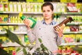 Woman chooses sprayer with insecticides in store Royalty Free Stock Photo