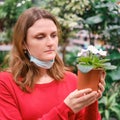 A woman chooses violets in a pot for flowers in a home garden. The sales of potted plants for a hobby during the epidemic of the