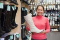 Woman chooses wintry shoes at shop Royalty Free Stock Photo