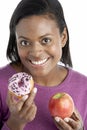 Woman Choosing Between Apple And Doughnut Royalty Free Stock Photo