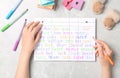 Woman choosing baby name at grey marble table, top view Royalty Free Stock Photo