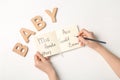 Woman choosing baby name at white table, top view Royalty Free Stock Photo