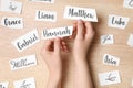 Woman choosing baby name at wooden table, top view Royalty Free Stock Photo