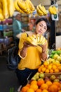 Woman choosing bananas in fruit and vegetable section of supermarket Royalty Free Stock Photo