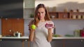 Woman choosing between cake and apple on kitchen. Woman choosing cake Royalty Free Stock Photo