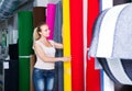 woman choosing carpet in housewares hypermarket.