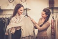 Woman choosing clothes with shop assistant Royalty Free Stock Photo