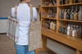 Woman choosing cotton bag at eco-friendly store